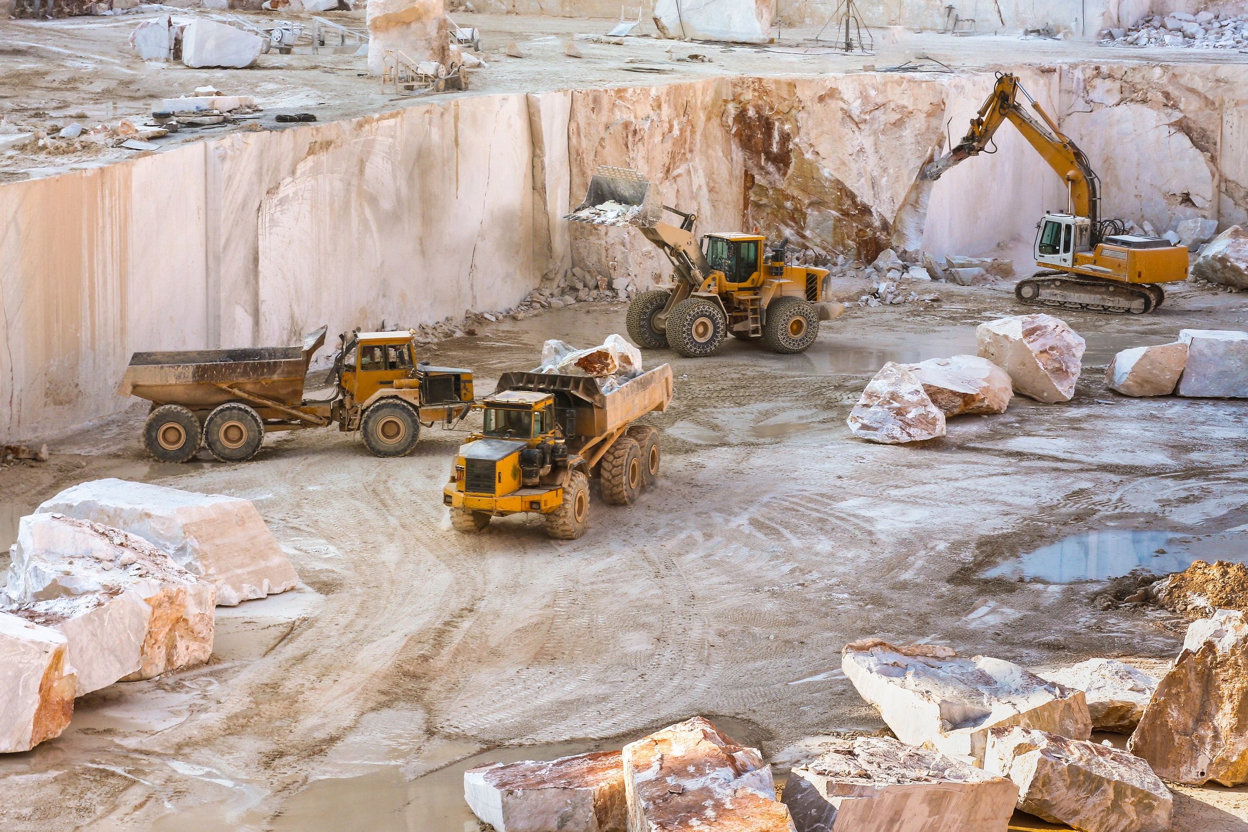 Marble quarry scene with large blocks and machinery, wide view