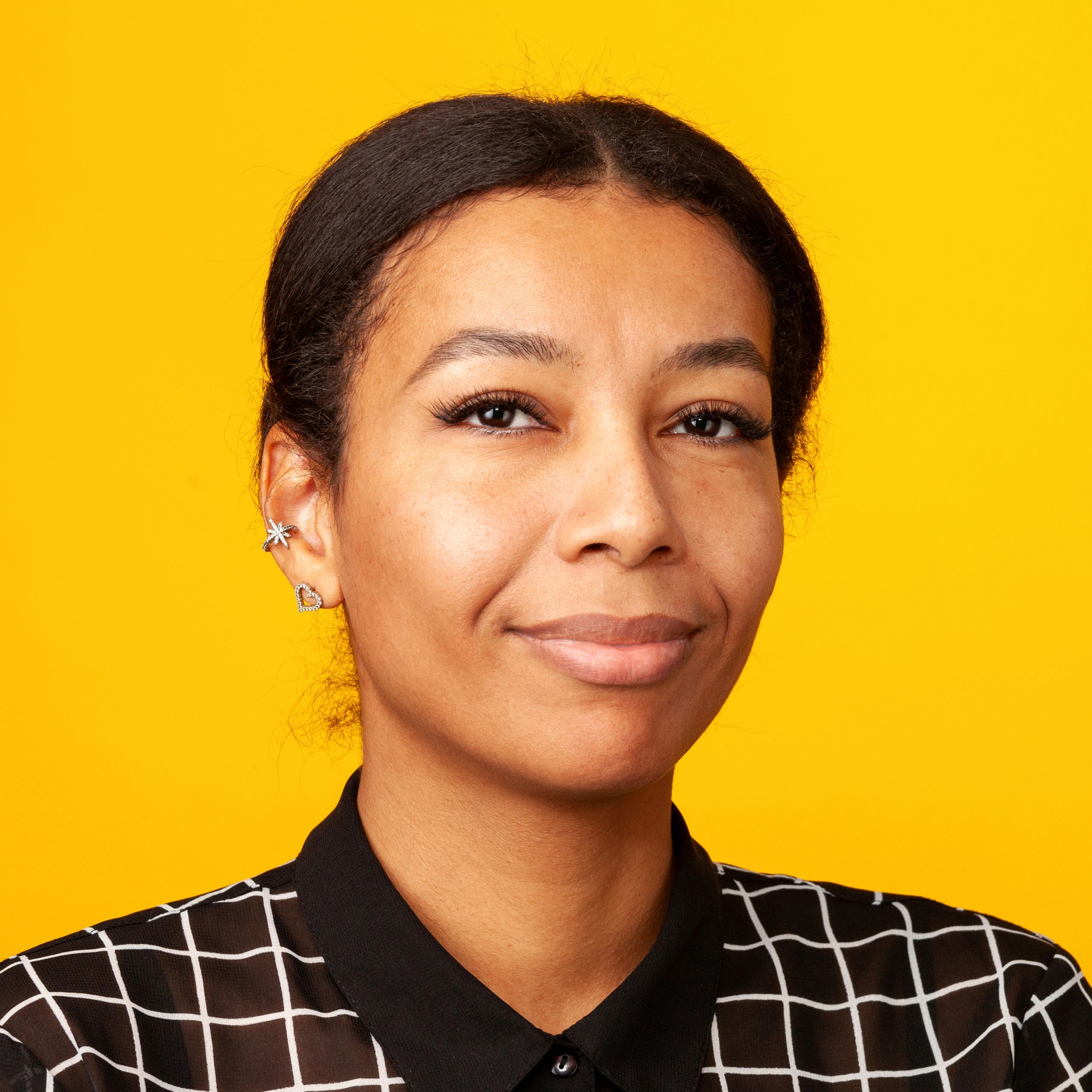 Studio portrait of a cheerful middle aged woman against a yellow background